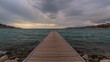© TheWaterMeloonProjec - Wooden dock extending into the sea under an overcast sky