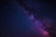 © Emin - Bright streak of light crossing the dark night sky with a vibrant purple and blue galaxy backdrop