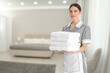 © New Africa - Chambermaid with clean towels in hotel room
