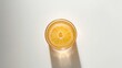 © AbstractAI - Citrus juice in a transparent cup against a plain white backdrop