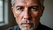 © amorn_m - Close-Up Portrait of a Mature Man with Gray Hair and Intense Eyes in an Indoor Setting