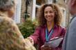 © Eve - Smiling social worker greeting senior couple at home, shaking hands outdoors. Friendly professional providing community support, healthcare visit or social service assistance concept.