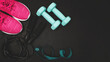 © O.Farion - Top view of pink sneakers, blue dumbbells, jump rope and measuring tape on dark background with copy space, fitness equipment flat lay concept
