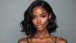 © miss irine - Beautiful black woman with pro makeup, wavy dark hair. Young attractive african american model with perfect glowing skin looks at camera. Glamour female face with nude lipstick poses in studio on