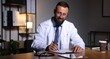 © New Africa - Doctor writing notes at table in clinic during night shift
