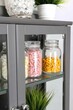 © Konstiantyn Zapylaie - Modern cabinet with glass jars filled with colorful capsules and green plants
