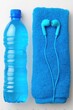 © Konstiantyn Zapylaie - Blue water bottle and towel with earbuds on a clean white background