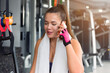 © as-artmedia - Fitness girl taking a break and calling on phone in gym