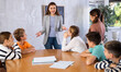© JackF - Portrait of female teacher giving lesson to children in school indoors
