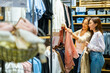 © CandyRetriever  - Happy Asian woman family mother and daughter shopping together at department store. Senior mom and adult child choosing and buying clothes at clothing shop. Mother's day and consumerism concept.