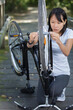© auremar - woman is fixing the electric bicycle in the park