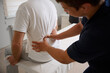 © Василь Івасюк - Chiropractor performing manual back adjustment on patient in medical clinic. Physiotherapy, spinal alignment, and rehabilitation treatment for lower back pain relief.