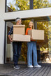 © zinkevych - Senior couple carrying boxes together at home porch smiling