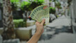 © Krakenimages.com - Hand holding argentine pesos on a city street showcasing 500 banknotes outdoors with blurred urban background, evoking commerce and finance with male presence.
