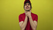 © Krakenimages.com - Delivery man in red uniform clutching throat and grimacing with strained expression in yellow studio; distress.
