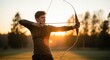 © Fabio - Young archer aiming with a recurve bow during a beautiful sunset. Man practicing archery in a field with golden hour light. Concept of focus, skill, precision, and goals.
