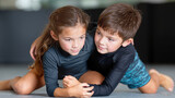 boy and girl training grappling techniques during kids MMA class