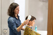 © Antonio Recena - Mother combing her 10-year-old son's hair in the bathroom before school