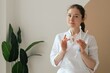 © Forewer - Medicine, healthcare and people concept - Friendly family doctor at hospital. Close up Woman therapist in white uniform with stethoscope on light background