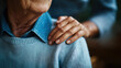 © Carmen - elderly Caucasian man sitting with elderly female's hand resting on his shoulder, Elder care concept