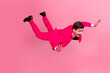 © deagreez - Energetic young man in vibrant pink suit posing stylishly on a bright background, expressing fun and confidence