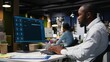 © DC Studio - African american male checking web AI chatbot responses for some tasks, working after hours to meet business objectives. Problem solving with futuristic tech and machine learning.