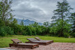 © mariano - Wooden lounge chairs with mountain view on a cloudy day