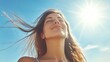© pariimage - horizontal portrait of fit woman basking in sunlight arms slightly raised face tilted upwards wind blowing hair serene expression clear sky as backdrop summer vitality and freedom