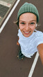 © Cavan Images - Young woman  rides a skateboard wearing green beanie on urban street