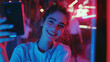© ndari - A young woman takes a selfie, illuminated by vibrant neon light, radiating happiness