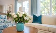 © simba kim - beautiful bright and happy interior designed living room with big windows. There is a teal vase of white roses. Charleston southern charm.