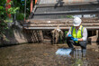 © SAHARAT - Environmental engineer collect water samples from drainage canals around the city and quality test