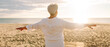 © maxbelchenko - An older woman with gray hair walks along a sunlit sandy beach. The elderly woman enjoys the seascape, feeling the freedom of dawn. Concept of a happy retirement, nature.