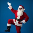 © Thomas Dufranne - fête de Noël, Père Noël funky et fou chantant et dansant sur des chansons, mélodie sonore, écouter la musique, danser, porter un chapeau de Noël élégant et des bretelles, isolé sur fond bleu
