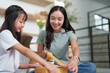 © Natee Meepian - Creative unpacking. Mother and daughter working together to seal boxes.
