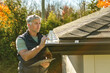 © Louis-Paul Photo - man standing on steps inspecting house roof