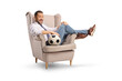 © Ljupco Smokovski - Excited man sitting in an armchair and holding a football