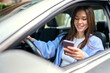 © insta_photos - Young happy woman driver sitting inside car holding smartphone using gps navigation map app on mobile phone looking at cellphone chacking traffic on city roads. Driving applications concept.