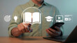 © MdSona - Digital Education and Online Learning Concept Man Interacting with Educational Icons on Screen Using Smartphone and Laptop for Study