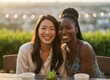 © 5 Grace Media - Close-up portrait of two beautiful diverse women smiling at an outdoor cafe at sunset