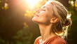 © Wee Ha - Blonde woman with eyes closed inhaling deeply outside among dense forest greenery enjoying warm afternoon light.