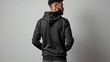 © Andrew505 - Man in a blank black hoodie, back view. Apparel mockup template for urban streetwear fashion or logo design.