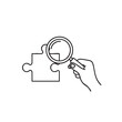 © Alamin - Hand holding a magnifying glass over a puzzle piece outline