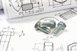 © bayurov - Printed engineering drawings and metal bolts.