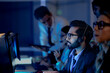 © ultramansk - Focused male team leader headset on points screen provides clear direction colleagues late night modern tech hub achieving operational goals project success now leadership guides team forward boost.
