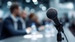 © Bussakon - A microphone is ready for a speaker at a formal business conference panel discussion