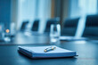 © Alena - Notepad for agenda kept on table in empty corporate conference room before business meeting in blue tone