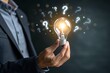 © SyedAbdulRehman - Businessman holding glowing lightbulb and question mark with copy space for creative thinking idea and problem solving concept.