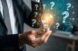 © SyedAbdulRehman - Businessman holding glowing lightbulb and question mark with copy space for creative thinking idea and problem solving concept.