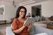 © fizkes - Happy Hispanic gadget user woman using smart application on tablet